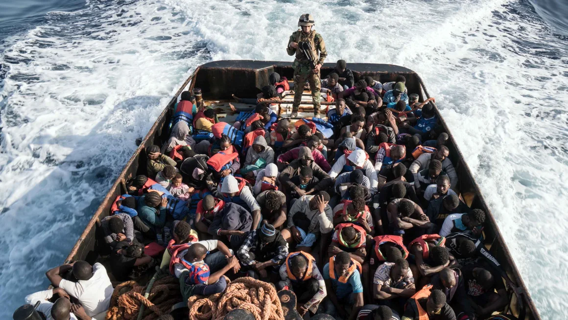 A member of the Libyan coast guard stands on a boat after picking up migrants off of the town of Zawiyah, 45 kilometres west of the capital Tripoli, in June 2017